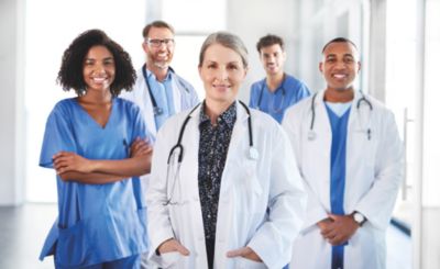 Cliniciens en blouses médicales et en blouses blanches se tenant dans un couloir d’hôpital