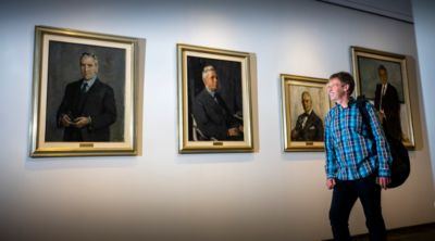 Mark Johnson walking past portrait gallery of historic Philips leaders