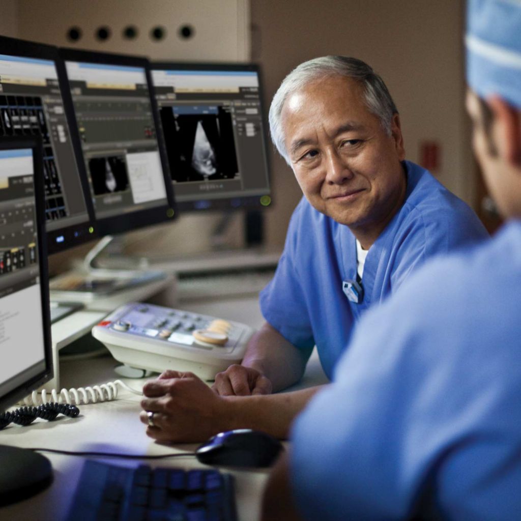 Two medical professionals reviewing patient information on monitors