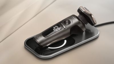 Afeitadora el&eacute;ctrica S9000 Prestige cargando de forma inal&aacute;mbrica en su base de carga Qi.