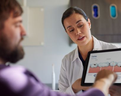 A dental professional holding the guide talks with patient