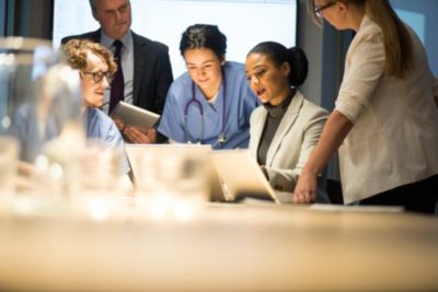 Healthcare professionals in a meeting around laptops