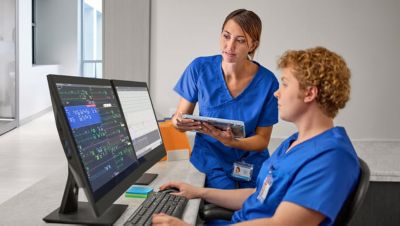 Clinicians analyzing diagnostic imaging on dual monitors in radiology setting