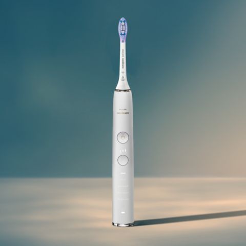 Man using a DiamondClean Smart with Premium Plaque Control brush head looking in a mirror