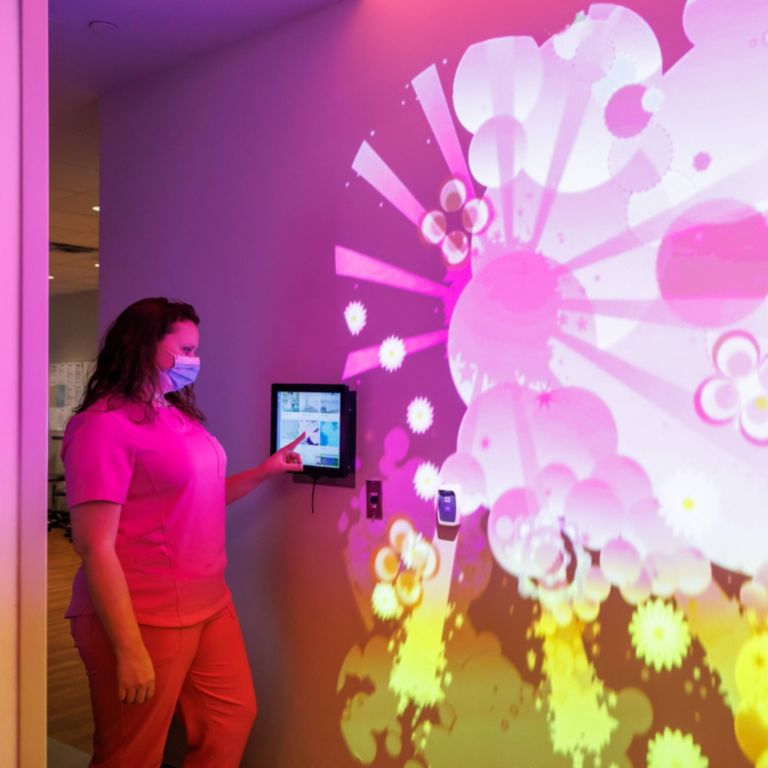 Nurse selecting Ambient Experience theme ‘Fantasy’ in X-Ray room at Children’s of Alabama