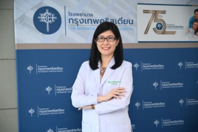 ภมดา สุวรรณพานิช ยืนอยู่ด้านหน้าป้ายจัดแสดงครบรอบ 75 ปี โรงพยาบาลกรุงเทพคริสเตียน