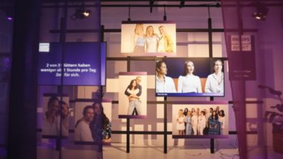 Ausstellungswand mit Familienporträts und fürsorglichen Botschaften