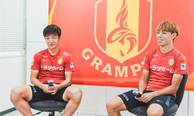 ームロゴの前で座って話す名古屋グランパスの選手たち