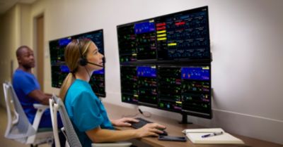 Two media professionals monitoring patient vital signs on multiple screens
