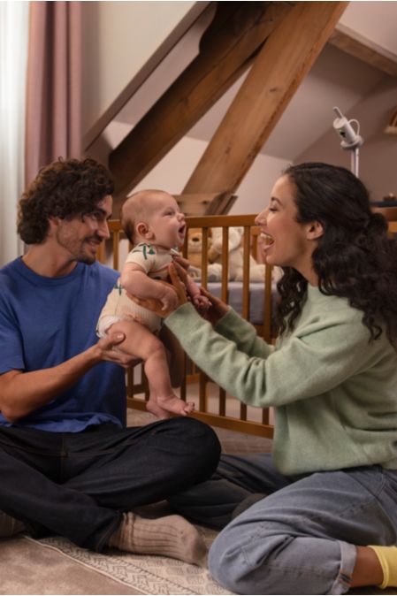 Ein Paar beobachtet sein Baby über das Telefon und das Babyphone