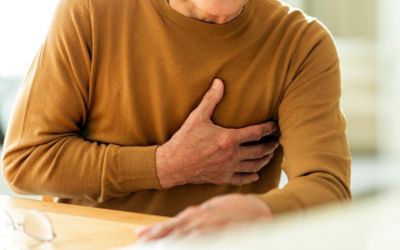 心臓に不快感を与える可能性のある胸を押さえている高齢男性