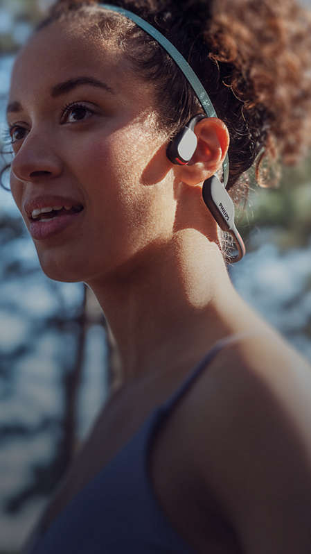 Close-up van een vrouw die sportkoptelefoon met bone conduction