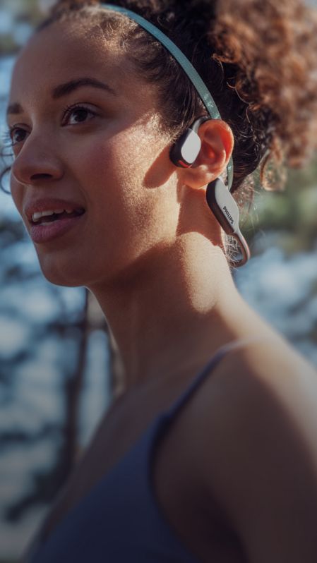 Photo en gros plan d'une femme portant un casque sport à conduction osseuse