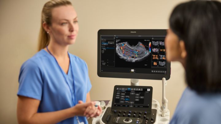 Patient consultation with Philips Alturion ultrasound - A clinician consults with a patient alongside the Philips Alturion ultrasound system and eV14-2v transducer during a women’s health appointment.
