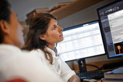 Un médico revisando datos del paciente en monitores duales