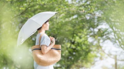 屋外で日傘をさして歩く女性