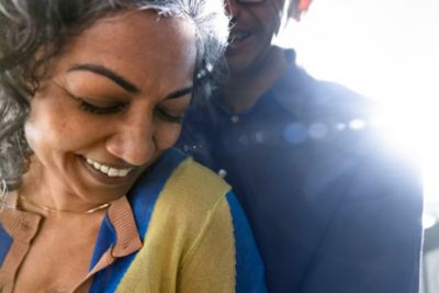 Two people standing close together in bright backlighting