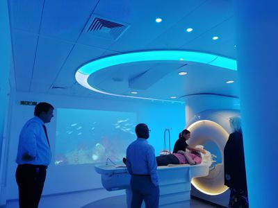 Healthcare professionals observing a Philips Ingenia Ambition 1.5T X MRI scanner demonstration in an ambient lighting suite