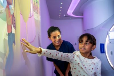A young girl engaging with the interactive medical wall display