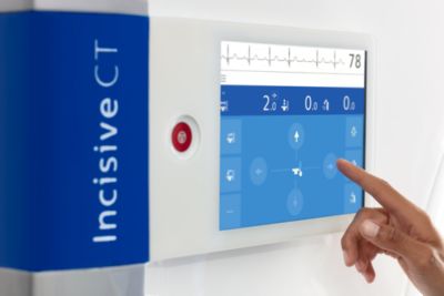 Clinician interacting with Incisive CT touchscreen control panel