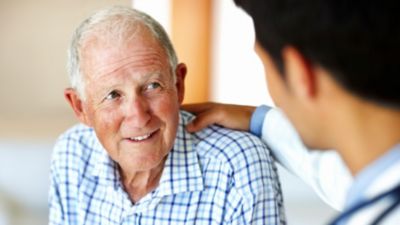 Elderly patient receiving support from healthcare professional during consultation