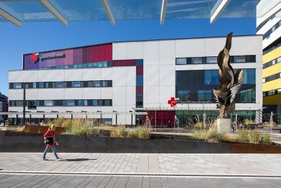 Modern hospital building with passerby outside main entrance