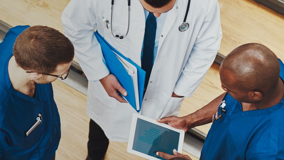 Doctors and nurses look at a tablet