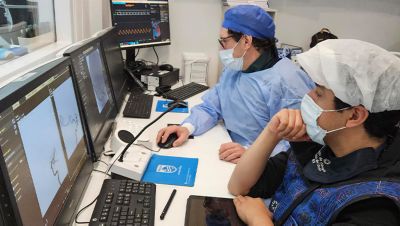 Clinicians analyzing angiography images on workstation using Philips Azurion platform