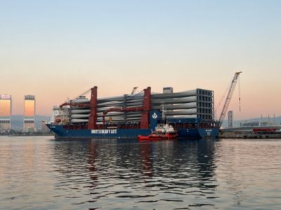 Tungt fragtskib transporterer vindmøllevinger i havn