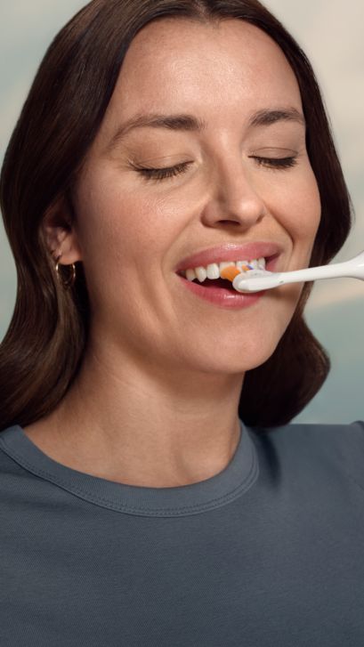A woman brushing with Philips Sonicare 7400.