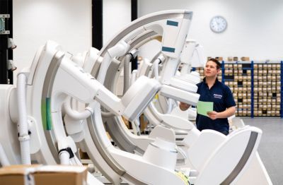 A factory worker overseeing refurbished equipment