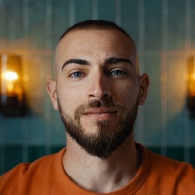 Primer plano de un hombre joven con una barba bien cuidada mirando a c&aacute;mara.