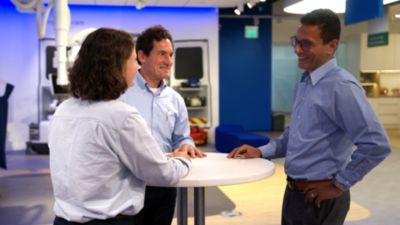 Philips employees discussing at high table in modern office space