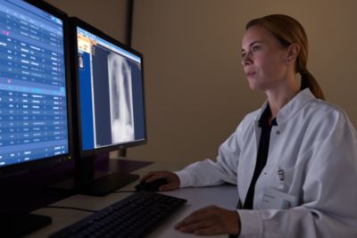 Radiologista revisando imagens médicas usando o Philips Radiology Smart Assistant em uma sala de leitura