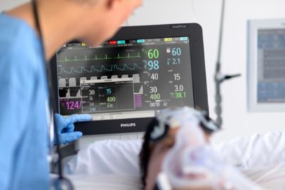 Nurse adjusts ventilator settings on Philips IntelliVue MX800 monitor