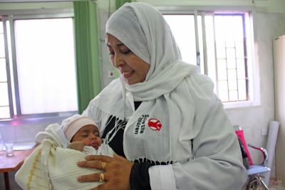 Nurse in Yemen holding infant in healthcare facility