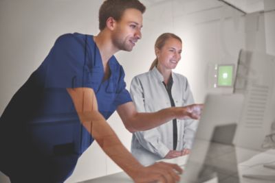 Clinician and medical professional reviewing scans on Philips imaging workstation in a radiology suite