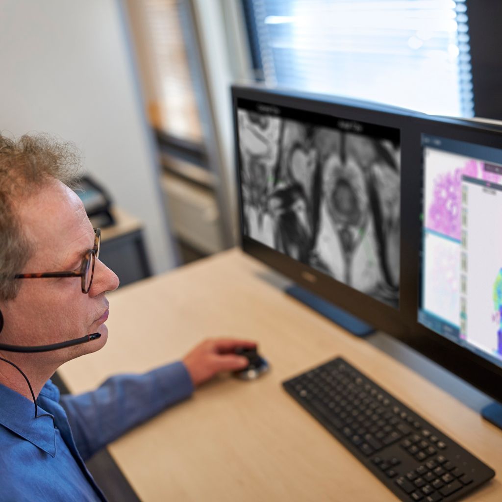 man at a computer screen looking at pathology results