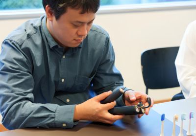 電動歯ブラシを検査するインタビュー参加者