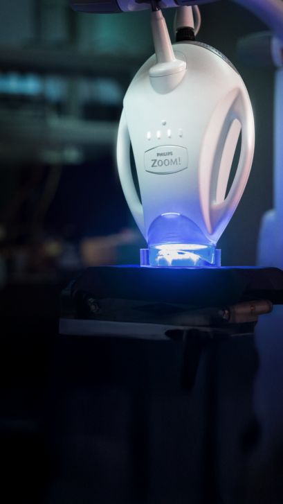 Un professionnel de la santé bucco-dentaire qui ajuste une lampe Philips Zoom!