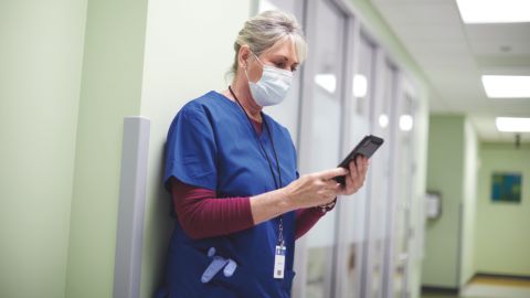 Nurse in hallway with mobile device