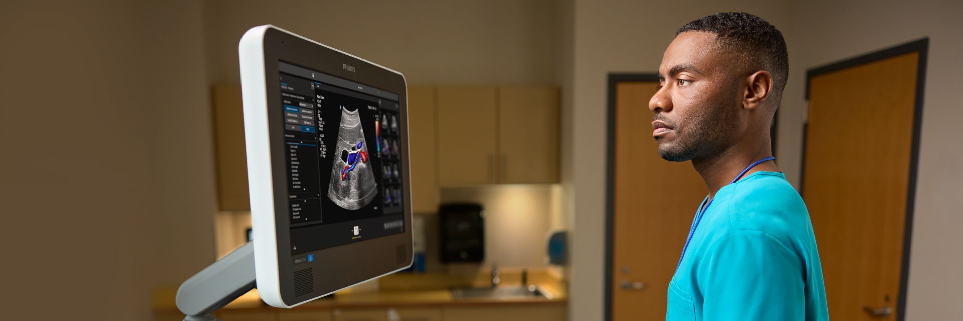 Sonographer looking at an ultrasound image while performing an abdominal scan on a patient 