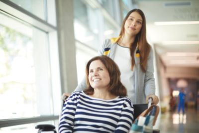 Woman pushing female patient in wheelchair