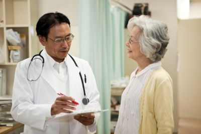 Médico revisando información médica con un paciente mayor en un entorno clínico