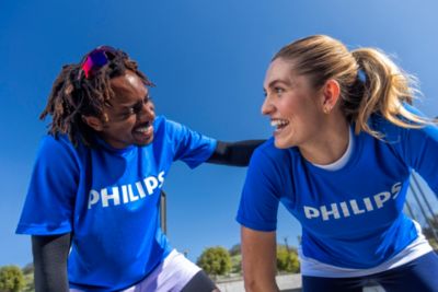 Two athletes in Philips shirts pause during an outdoor workout