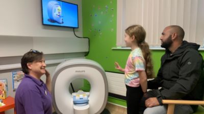 Child named Phoebe with parent and hospital staff using the Philips Kitten Scanner at Grantham and District Hospital