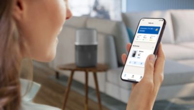 Person steuert einen Philips Luftbefeuchter über eine Smartphone-App