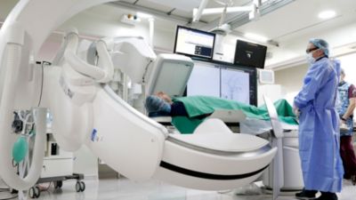 Clinician performing procedure using Philips Azurion C20 FlexArm in interventional suite