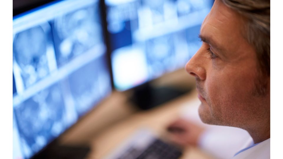 Clinician looks at radiology images on a monitor