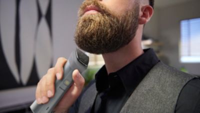 Man trimming beard with Philips multigroom trimmer